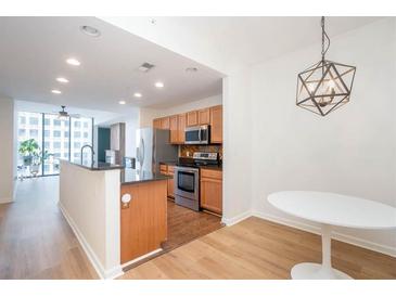 Open kitchen features wood cabinets, stainless steel appliances, and a large island at 3040 Peachtree Nw Rd # 815, Atlanta, GA 30305