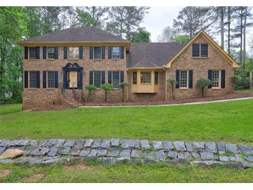 Charming brick home with black shutters, manicured landscaping, and a welcoming front entrance at 5621 Wildwood Trl, Lithonia, GA 30038