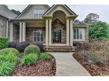 Inviting brick home entrance with a covered porch and landscaped walkway at 5195 Stefan Ridge Way, Buford, GA 30519