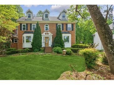 Charming brick home with manicured lawn, mature trees, and classic architectural details at 22 Oakwood Hills Dr, Suwanee, GA 30024
