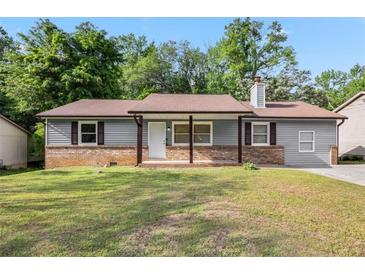 Charming single story home featuring brick accents, a well-manicured lawn, and inviting curb appeal at 6801 Red Maple Dr, Rex, GA 30273