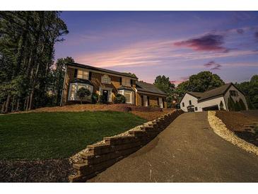 Beautiful brick home featuring a long driveway and well-manicured lawn at 180 Spring Ridge Trace, Roswell, GA 30076