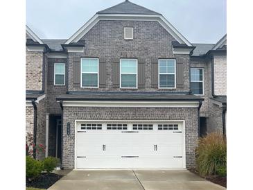 Charming brick townhouse with a two-car garage and decorative shutters at 2458 Morgan Creek Rd, Buford, GA 30519