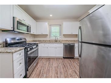 Updated kitchen featuring stainless steel appliances, granite countertops, and wood-look flooring at 3497 Glensford Dr, Decatur, GA 30032