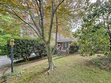 Charming home with lush landscaping and inviting front entrance with wooden stairs at 3220 Stoney Acres Nw Dr, Kennesaw, GA 30152