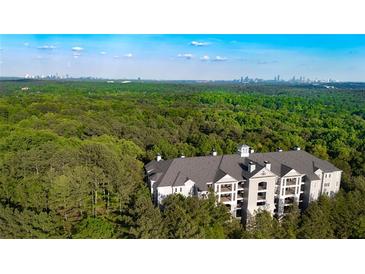 Stunning aerial view of condo building surrounded by trees with distant city skyline backdrop at 4100 Paces Se Walk # 4306, Atlanta, GA 30339