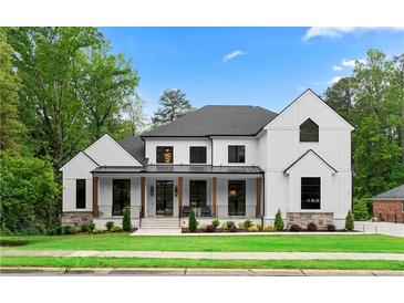 Stunning modern farmhouse with white siding, black trim, and a welcoming front porch perfect for relaxing at 575 Indian Hills Pkwy, Marietta, GA 30068