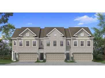 Charming exterior elevation of a new construction townhome featuring a two-car garage and professionally landscaped front yard at 190 Abbotts Crossing Cir, Conyers, GA 30094