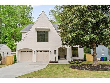 Charming two-story home features a white brick facade, arched entryway, and a two-car garage at 3006 Skyland Ne Dr, Brookhaven, GA 30319