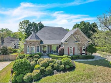 Charming home with stone accents, manicured landscaping, and a well-maintained lawn at 147 Gold Bridge Xing, Canton, GA 30114