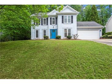 Charming two-story home with a well-maintained lawn and a bright blue front door at 6939 Waters Edge Dr, Stone Mountain, GA 30087