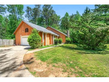 Charming home with beautiful wood siding, a well-manicured lawn, and attached garage at 3955 Old Fairburn Sw Rd, Atlanta, GA 30331