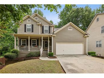 Charming two-story home with a welcoming front porch, a two-car garage, and a well-manicured lawn at 4560 Weathervane Dr, Alpharetta, GA 30022