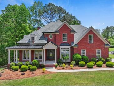 Beautiful brick home with a manicured front yard and a covered porch, perfect for relaxing and enjoying the outdoors at 6615 Callanwalde Ct, Suwanee, GA 30024