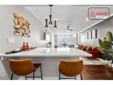 Stylish living room features a breakfast bar, hardwood floors, and an orange velvet sofa at 215 Piedmont Ne Ave # 1509, Atlanta, GA 30308