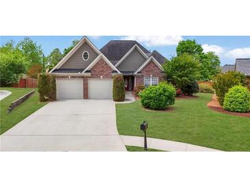 Charming brick home with a well-manicured lawn and a two-car garage at 3425 Sweet Basil Ln, Loganville, GA 30052
