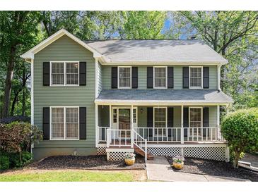 Charming two-story home featuring a welcoming front porch and a well-maintained lawn with mature trees at 929 Hampton Nw Trl, Lilburn, GA 30047