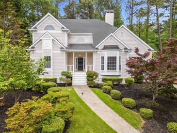 Charming home with a landscaped front yard featuring mature trees and manicured bushes at 1633 Clifton Downs Ct, Kennesaw, GA 30144