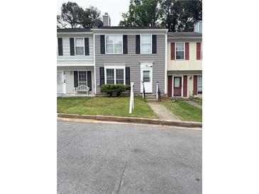 Charming townhome featuring a well-maintained lawn, neutral siding, and black shutters at 2880 Aspen Woods Entry, Doraville, GA 30360