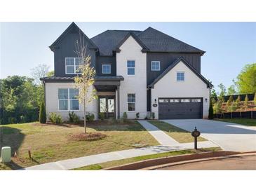 Charming two-story home featuring a mix of painted brick and vertical siding, an attached two-car garage, and well-manicured lawn at 750 Garden Reserve Ln, Alpharetta, GA 30005