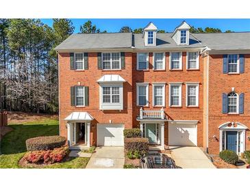 Inviting brick townhome showcasing manicured landscaping and an attached garage at 5589 Trace Views Dr, Norcross, GA 30071