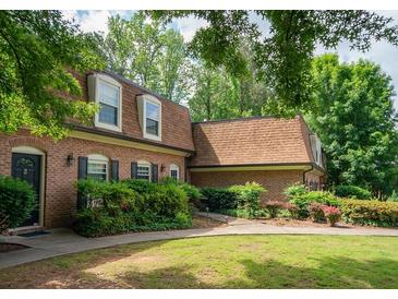 Traditional brick home featuring a well-maintained lawn, mature trees, and classic architectural details at 1261 Lavista Rd # N4, Atlanta, GA 30324
