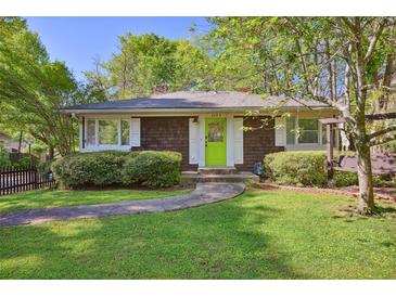 Charming home with cedar shake siding, manicured lawn, and a bright green front door at 2049 Oakview Se Rd, Atlanta, GA 30317