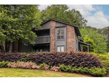 Inviting two-story condo with a brick facade, wooden balcony, and mature landscaping at 223 Tuxworth Cir, Decatur, GA 30033