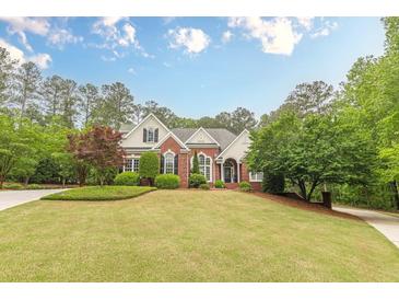 Stunning two-story brick home featuring lush landscaping, manicured lawn, and a welcoming facade at 9465 Grande Dr, Winston, GA 30187