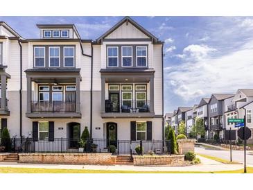 Charming townhome with a gray and white facade, a small balcony, and a well-manicured lawn at 834 S Columbia Dr, Decatur, GA 30030