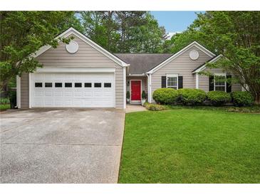 Charming single-story home features a well-maintained lawn, a two-car garage, and a bright red front door at 141 Springbrooke Trl, Dallas, GA 30157