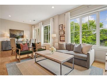Bright living room featuring a comfortable couch, hardwood floors, and large windows offering ample natural light at 1430 Dresden Ne Dr # 230, Brookhaven, GA 30319