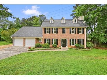 Charming two-story brick home with a well-manicured lawn and a two-car garage at 2801 Holly Oaks Dr, Marietta, GA 30062