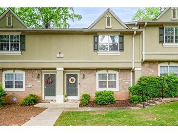 Charming townhome featuring a well-manicured lawn and inviting entrances adorned with decorative wreaths at 6900 Roswell Rd # J2, Atlanta, GA 30328
