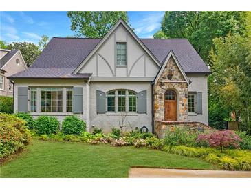 Charming Tudor-style home with stone accents, manicured lawn, and lush landscaping at 893 E Rock Springs Ne Rd, Atlanta, GA 30306