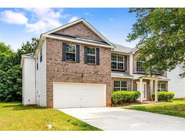 Charming two-story brick home featuring an attached garage and well-maintained lawn at 1492 Saint George, Conyers, GA 30012