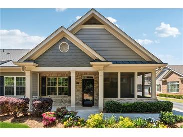 Charming home with beautiful landscaping, a brick facade, and a welcoming front porch at 1680 Bluestone Dr, Cumming, GA 30041