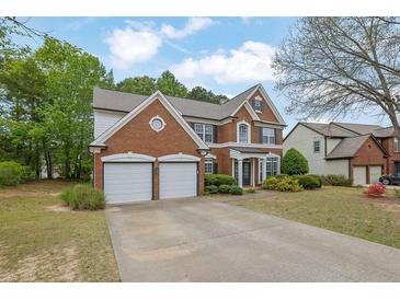 Charming brick home with a two-car garage and well-manicured lawn in a suburban setting at 5155 Amberden Hall Dr, Suwanee, GA 30024