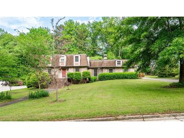 Charming brick home with manicured lawn and mature trees, providing shade and curb appeal at 620 Shannon Green Sw Cir, Mableton, GA 30126