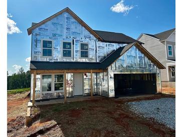 Exterior view of a new two-story home with an attached two-car garage and covered front porch, ready for finishing touches at 72 Warrior Ct, Braselton, GA 30548