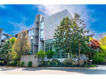 Modern building exterior with concrete accents, large windows, landscaping, and the address number 130 at 130 Arizona Ne Ave # 309, Atlanta, GA 30307