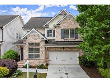 Charming two-story brick home featuring a two-car garage and beautifully landscaped front yard at 7340 Jamestown Dr, Alpharetta, GA 30005