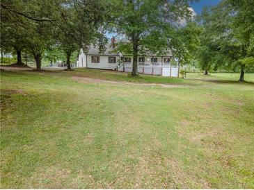 Charming home with a sprawling front yard and mature trees, offering a serene and private setting at 3241 Briscoe Rd, Loganville, GA 30052