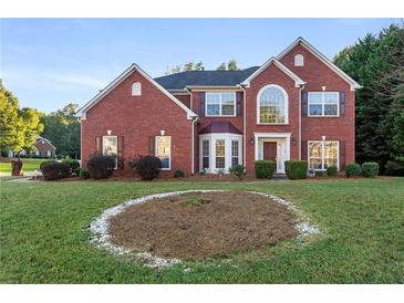 Charming two-story brick home with a well-manicured lawn and mature trees at 10 Bunker Lane St, Covington, GA 30014