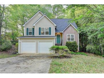 Charming two-story home with a two-car garage and well-maintained front yard, complemented by lush greenery at 1635 Rushing River Way, Suwanee, GA 30024