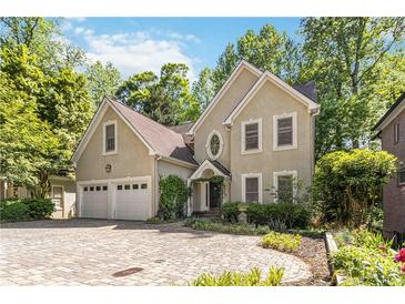 Elegant home featuring a circular driveway, two-car garage, and lush landscaping at 2651 Briarlake Ne Rd, Atlanta, GA 30345