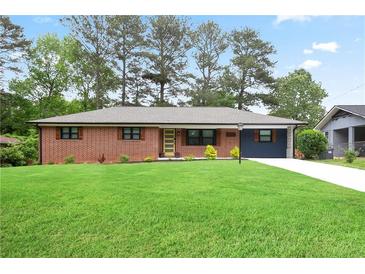 Charming brick home with a well-manicured lawn and a vibrant, yellow front door provides great curb appeal at 2738 Westchester Dr, Atlanta, GA 30344