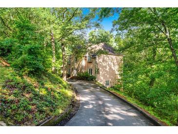 Secluded home featuring private drive surrounded by lush landscaping and mature trees at 5105 Jett Forest Trl, Atlanta, GA 30327