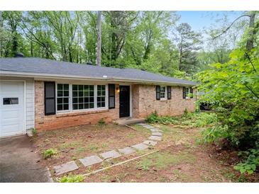 Charming brick home with black shutters, a stone path, and a lovely front yard at 980 Oakton Sw Dr, Marietta, GA 30060