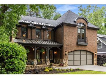 Beautiful brick home with a covered porch, arched garage, and mature landscaping creating a welcoming curb appeal at 2871 Parkridge Ne, Brookhaven, GA 30319